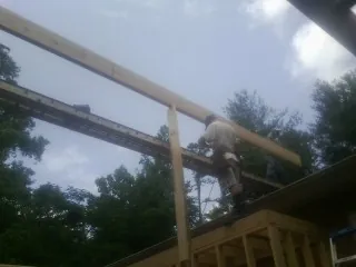 Carpenter setting a ridge beam over a new addition frame — Ice Dam Removal by Roofing Brothers in Cuyahoga Falls