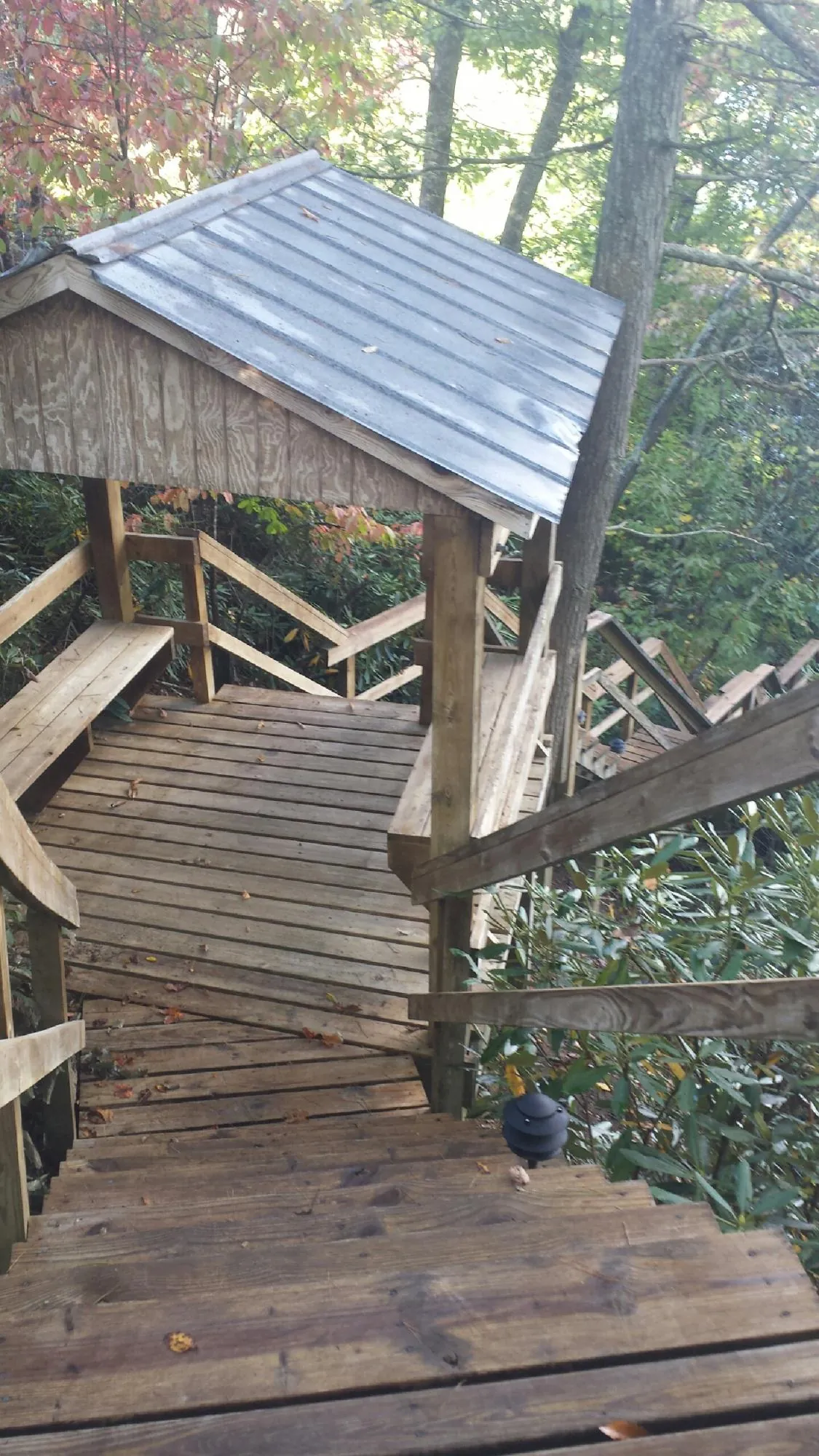 Metal roofed shelter over wooden steps on a wooded walkway — Skylight Repair & Installation work by our crew in Cuyahoga Falls