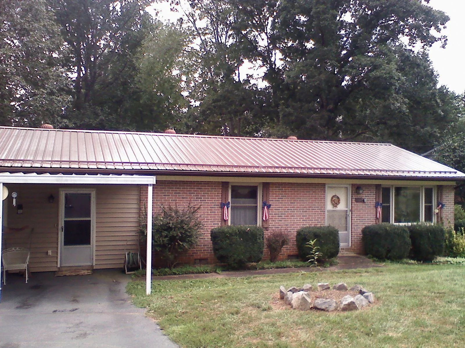 Bronze metal roof and carport on a brick ranch home — Roof Repair work by our crew in Cuyahoga Falls